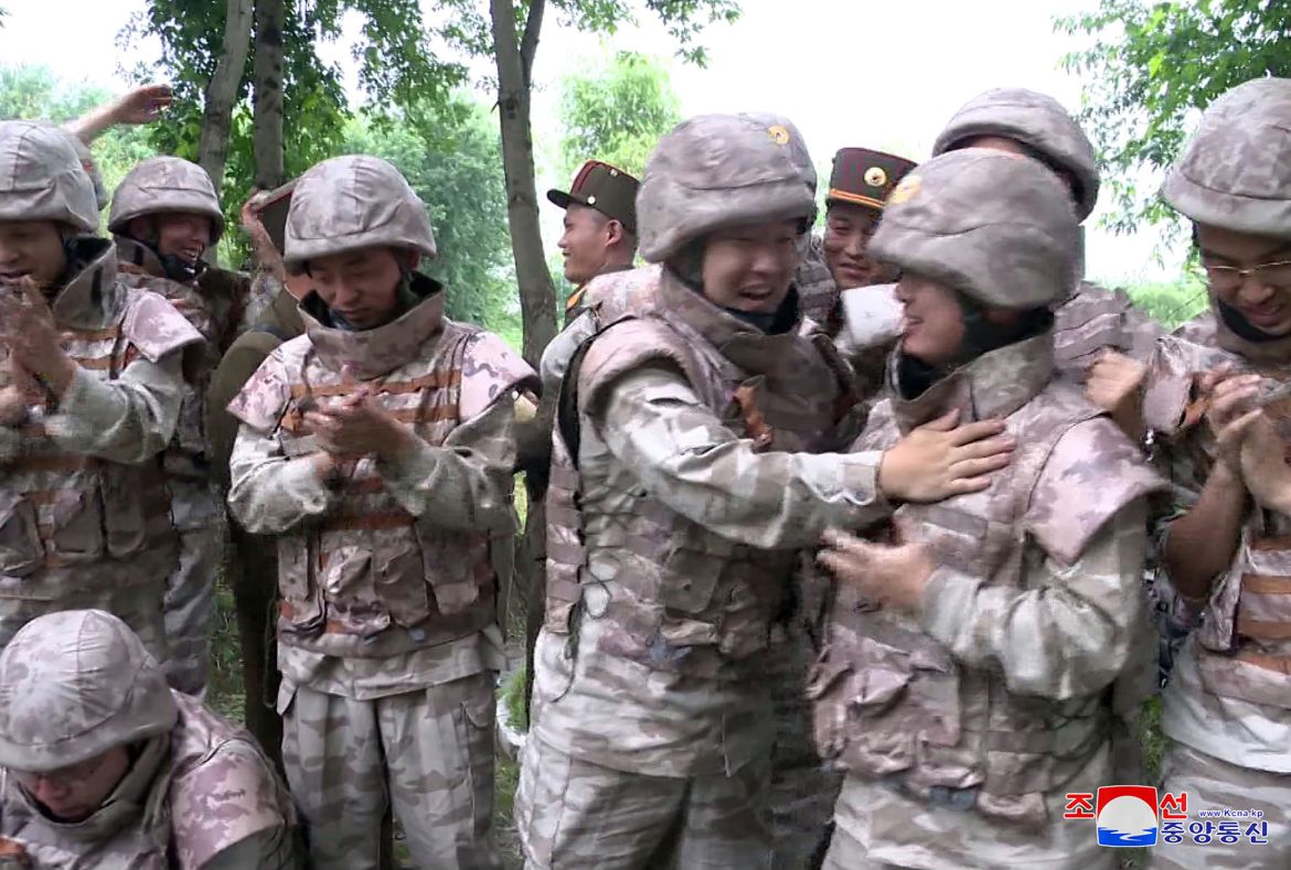 A group of North Korean soldiers clapping and hugging each other following the launch.