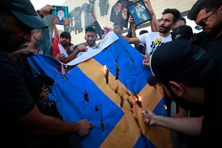 Iraqi protesters burning a Swedish flag