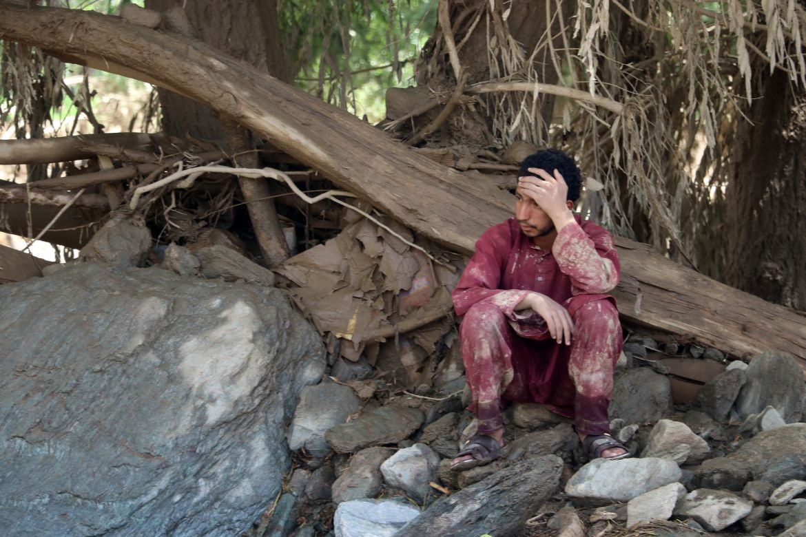An Afghan resident sits near his house that was damaged in flash floods in the Jalrez district