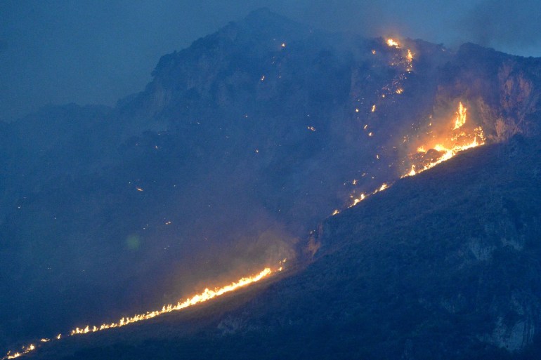 This photo obtained from Italian news agency Ansa shows a vast fire spreading on hills in the area of Monte Grifone and the town of Ciaculli around Palermo, Sicily