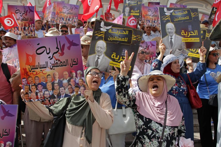 People lift placards demanding the release of political prisoners during an anti-government demonstration in Tunisia