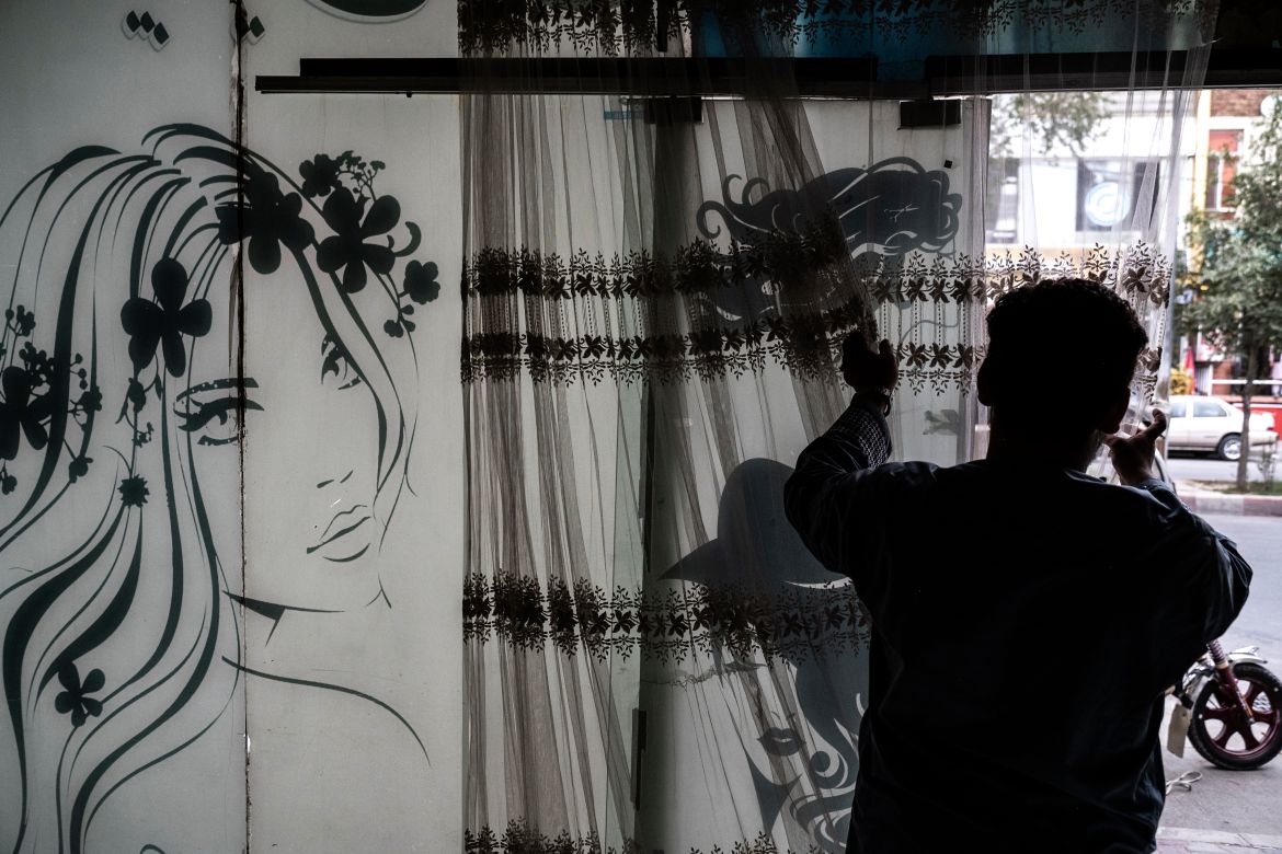 An afghan man remove curtains inside a beauty parlour