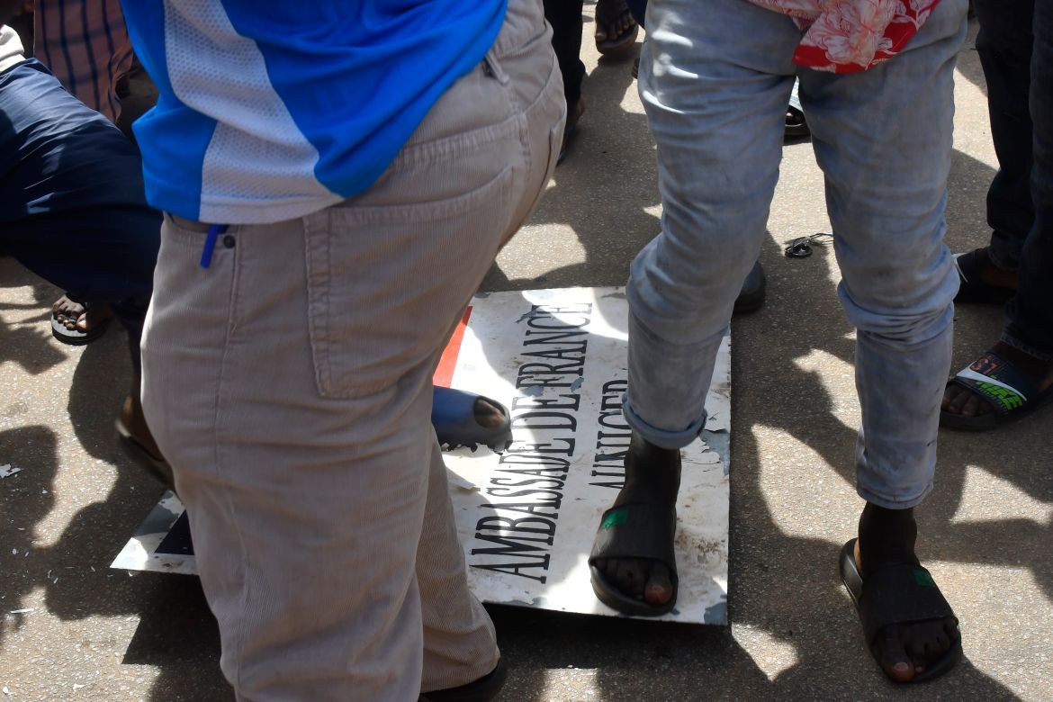 Protesters stomp over a sign taken from the French Embassy