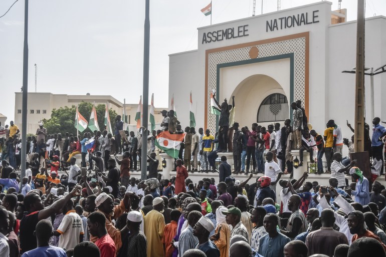 Pendukung mengibarkan bendera Nigeria saat mereka berkumpul untuk mendukung junta Niger