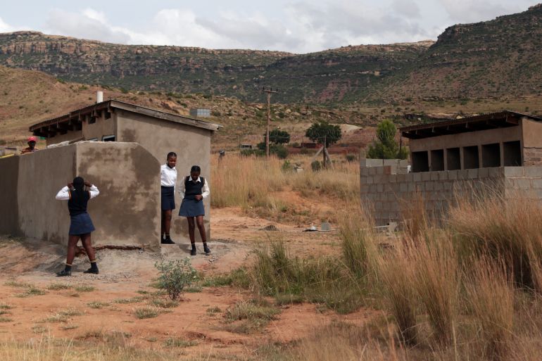 Girls stand near a pit latrine, at a school in Ghoboshiyane village, South Africa