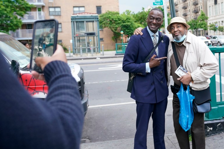 A man poses for a cellphone photo with a constituent on the streets of New York City.