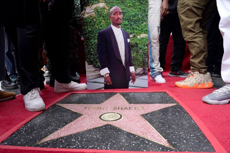 An image of the late rapper/actor Tupac Shakur appears near his new star on the Hollywood Walk of Fame during a posthumous ceremony in his honor