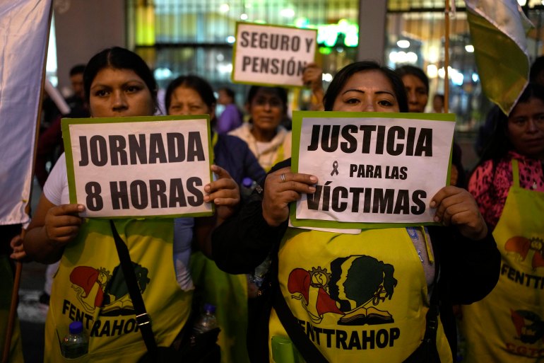 People dressed in yellow shirts hold up signs that read, "Jornada 8 horas" and "Justicia para las victimas"