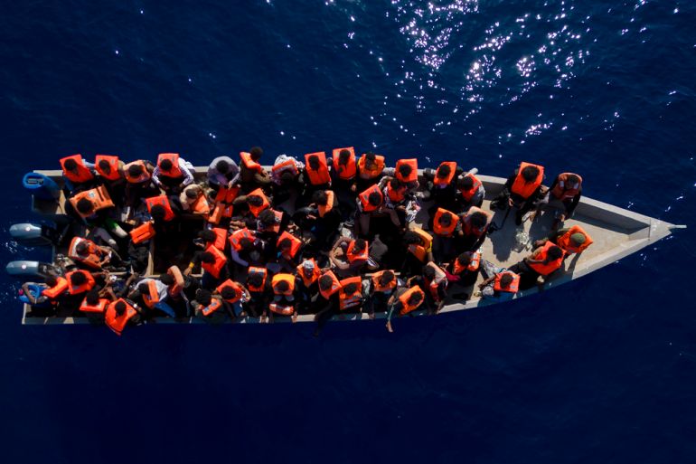 Migrants from Eritrea, Libya and Sudan sail a wooden boat before being assisted by aid workers of the Spanish NGO Open Arms in the Mediterranean Sea