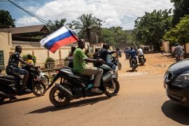 Supporters of Capt. Ibrahim Traore parade wave a Russian flag in the streets of Ouagadougou, Burkina Faso, Oct. 2, 2022.