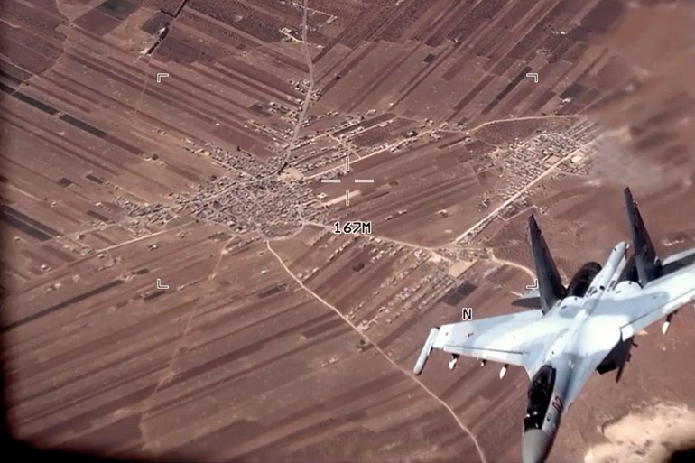 Кадр из видео, опубликованного ВВС США, показывает землю внизу и российский истребитель поблизости.  Хорошо виден его номер.