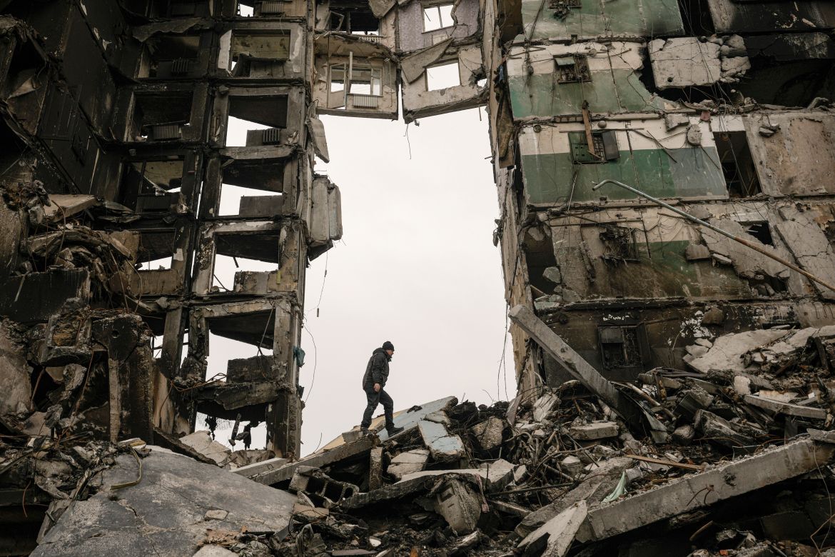 A resident looks for belongings in an apartment building destroyed during fighting between Ukrainian