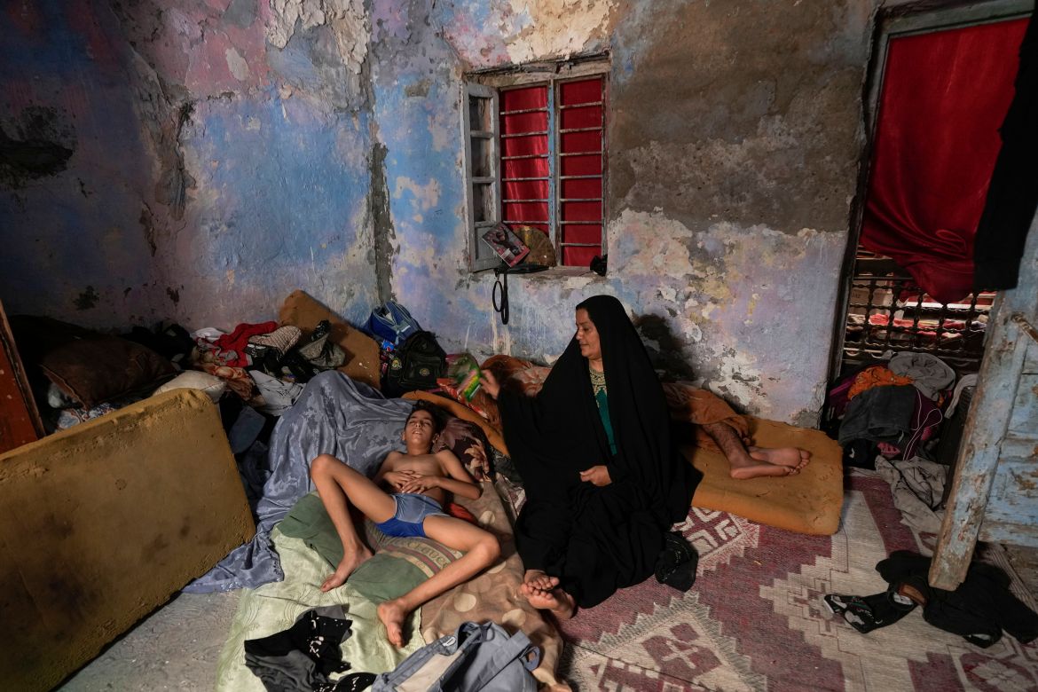 A Iraqi woman fans her child during a power outage at their home in Baghdad, Iraq,