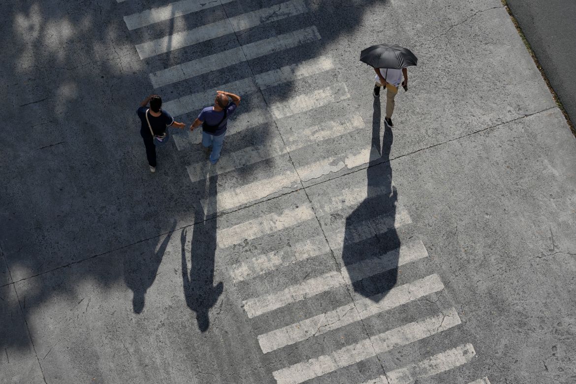 A man uses an umbrella to shield him from the afternoon sun in Manila, Philippines