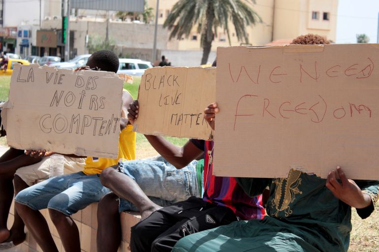 Migrants hold placards reading "Black Lives Matter" during a gathering in Sfax, Tunisia's eastern coast