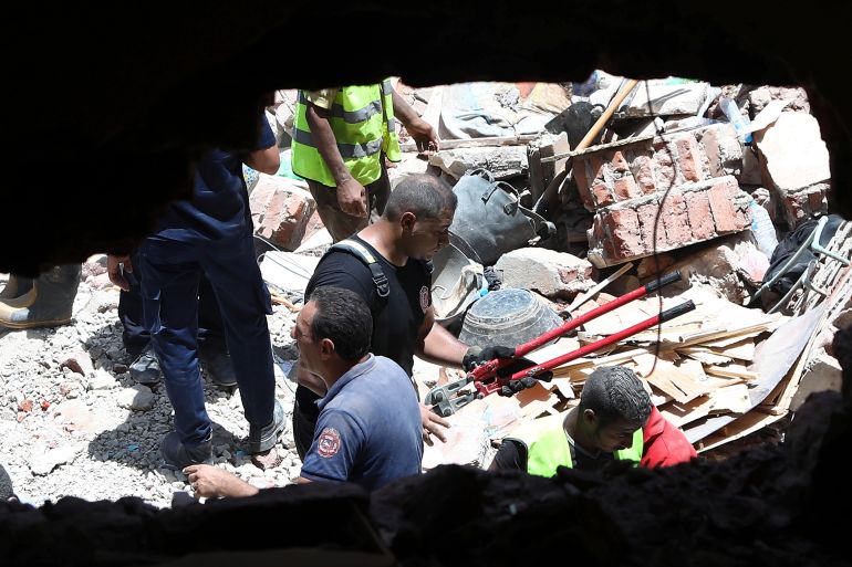 Rescuers search through the rubble of a collapsed five-story apartment building in Cairo, Egypt