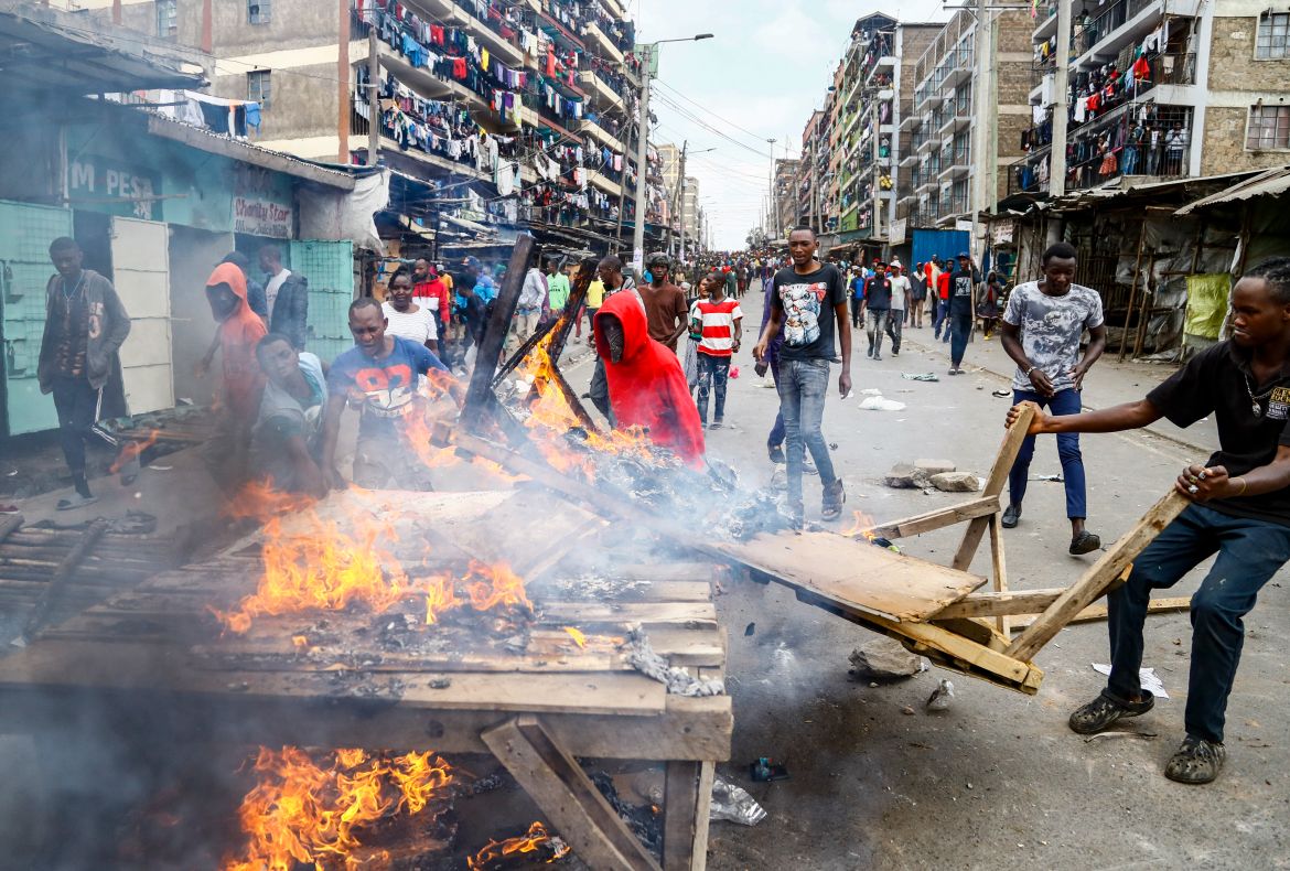 People clear the road during clashes in the Mathare area