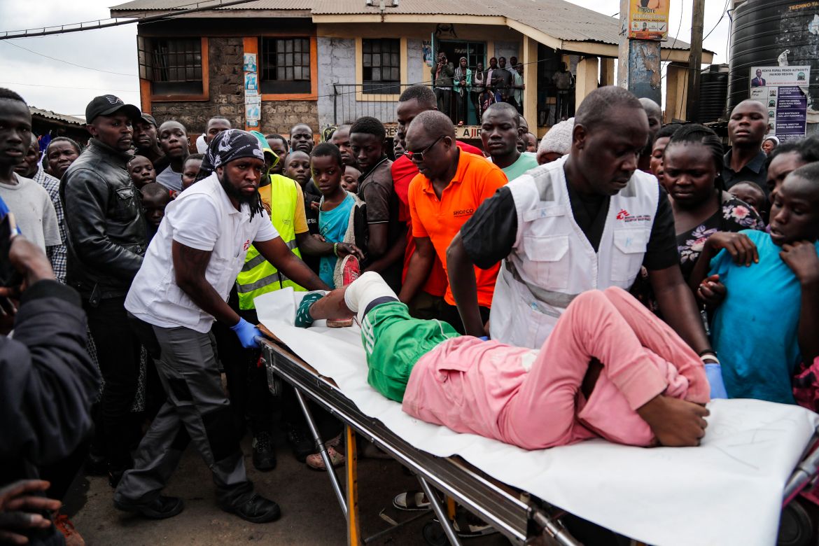 Medecins Sans Frontieres (MSF) responders carry a young boy to an ambulance, as residents said he was wounded in the leg by a stray bullet while standing outside his home in Mathare area of Nairobi,