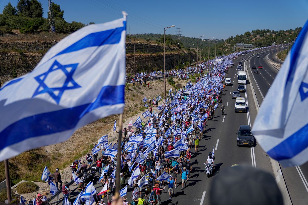 Thousands of Israelis march along a highway towards Jerusalem