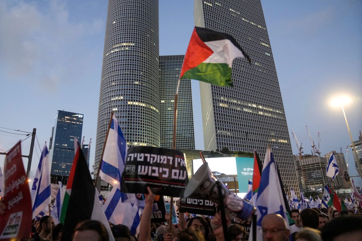 Demonstrators wave the Israeli and Palestinian flags
