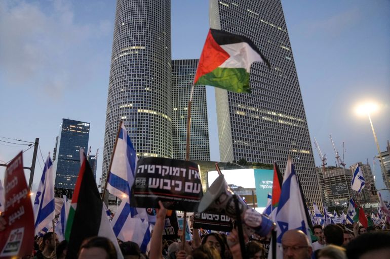 Demonstrators wave the Israeli and Palestinian flags during a protest against plans by Prime Minister Benjamin Netanyahu's government to overhaul the judicial system, in Tel Aviv