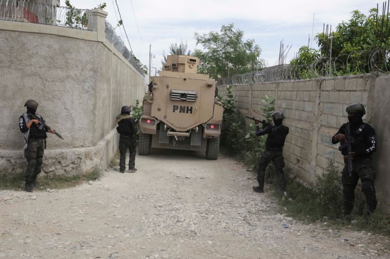 Haitian security forces accompany a vehicle into neighborhood