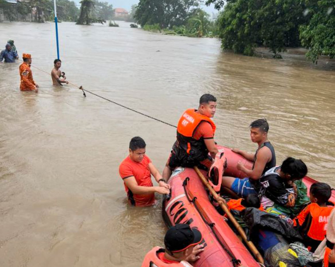 Rescuers use a rubber boat along floodwaters caused by Typhoon Doksuri as they evacuate residents to higher grounds in Bacarra, Ilocos Norte province, northern Philippines on Wednesday July 26, 2023.