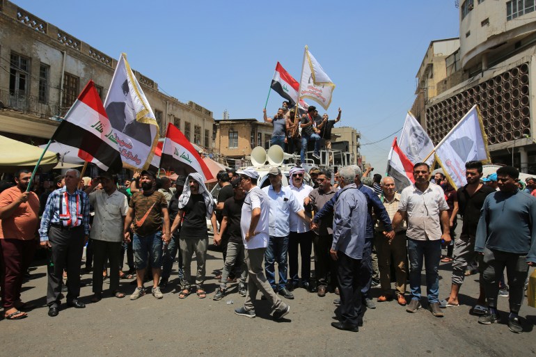 Demonstrators protest in front of the Iraqi central bank as currency plummets against the U.S. dollar, in Baghdad, Iraq, Wednesday, July. 26, 2023. Over the past two days, the market rate of the dollar jumped from 1,470 dinar per dollar to 1,570 dinar per dollar.