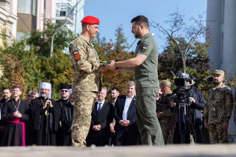 Zelenskyy, centre right, awards a serviceman during an event for marking Statehood Day in Mykhailivska Square in Kyiv