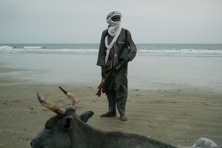 Almounzer Dicko berdiri di pantai panjang di luar Cap Skirring di Casamance