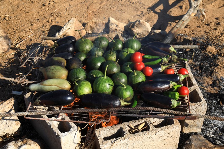 Roasting young watermelons, eggplants and tomatoes over an open fire