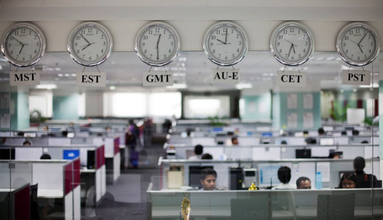 Workers are pictured beneath clocks displaying time zones in various parts of the world at an outsourcing centre in Bangalore, February 29, 2012. India's IT industry, with Bangalore firms forming the largest component, is now worth an annual $100 billion and growing 14 percent per year, one of the few bright spots in an economy blighted by policy stagnation and political instability. Picture taken on February 29, 2012. To match Insight INDIA-OUTSOURCING/ REUTERS/Vivek Prakash (INDIA - Tags: BUSINESS EMPLOYMENT SCIENCE TECHNOLOGY)