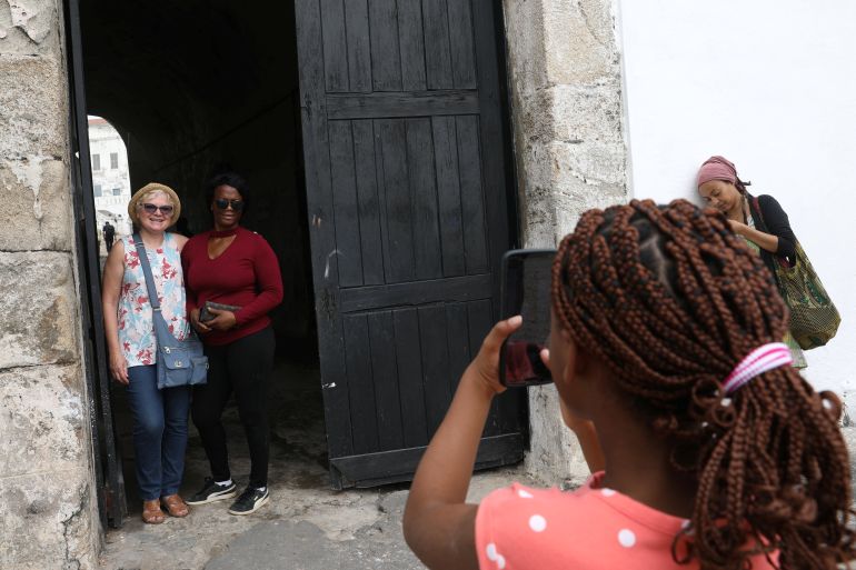 American tourist, Divine Koufahenou takes a picture of her Mother Afi and her friend Dawn Kravig at the 'Door of No Return' at the Cape Coast Slave Castle in Ghana