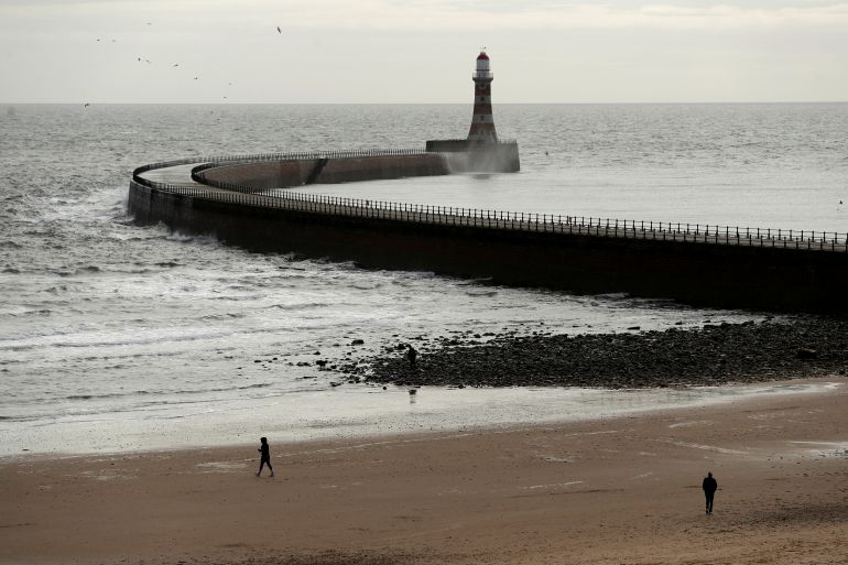 People take a stroll on Roker Beach, Sunderland, Britain