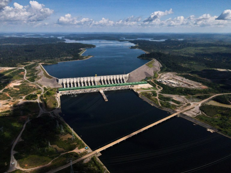 Uma vista aérea da barragem de Belo Monte atravessando um rio na Amazônia brasileira.