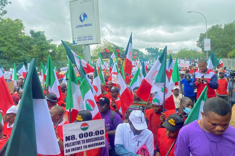 Members of the Nigerian Labour Union, holding flags and placards, march during a protest against fuel price hikes and rising costs, in Abuja, Nigeria August 2, 2023.