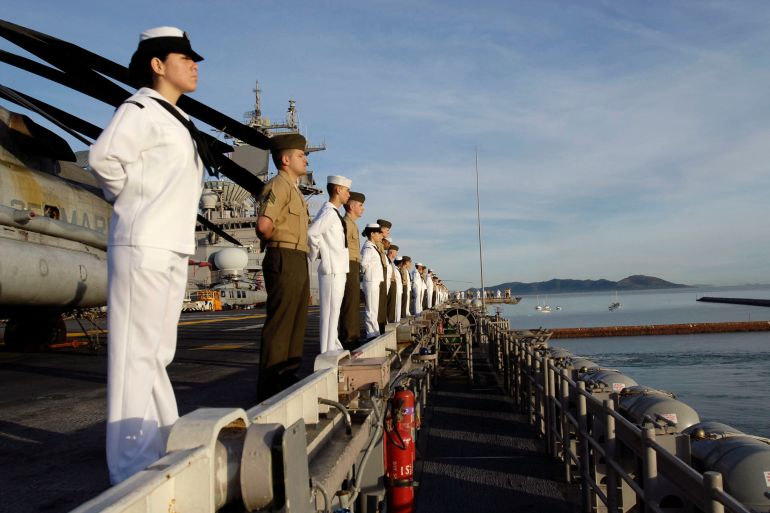 Sailors and Marines man the rails aboard amphibious assault ship USS Essex (LHD 2) during a scheduled port visit after the completion of Exercise Talisman Saber 2007. They line up along the edge of the ship, offering a salute.
