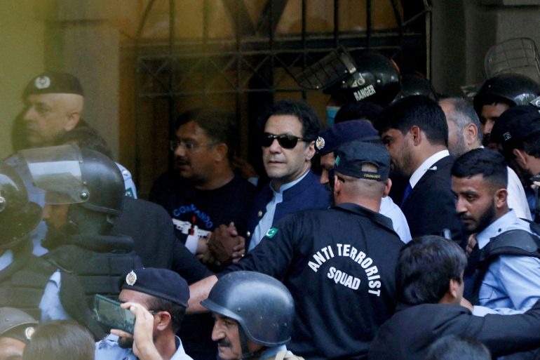 Security officers escort Pakistan's former Prime Minister Imran Khan