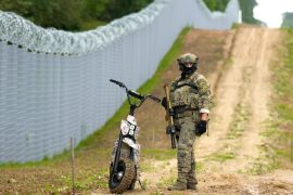 Latvian special unit Border Guard officer patrols along the fence at Latvia-Belarus border near Robeznieki, Latvia August 8, 2023. REUTERS/Ints Kalnins