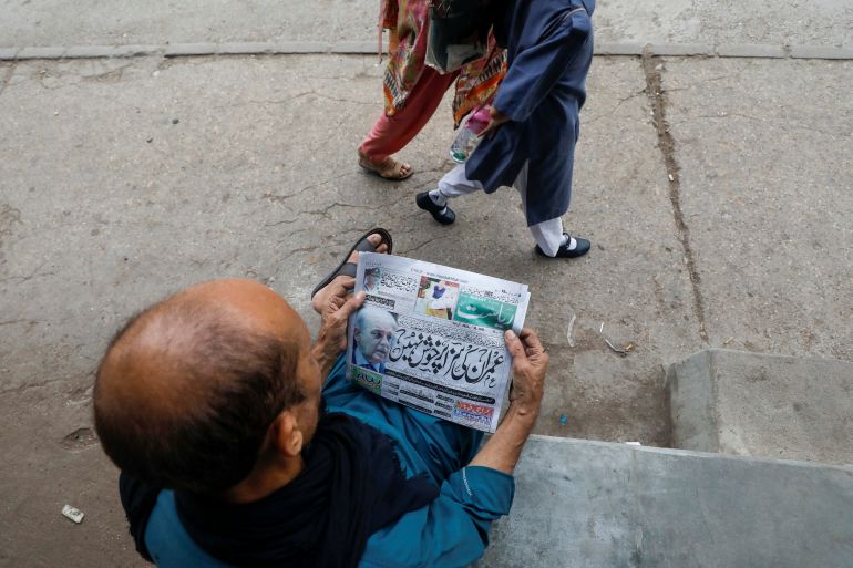 A man reads a newspaper, a day after Pakistan's parliament was dissolved by the president on Prime Minister Shehbaz Sharif's advice