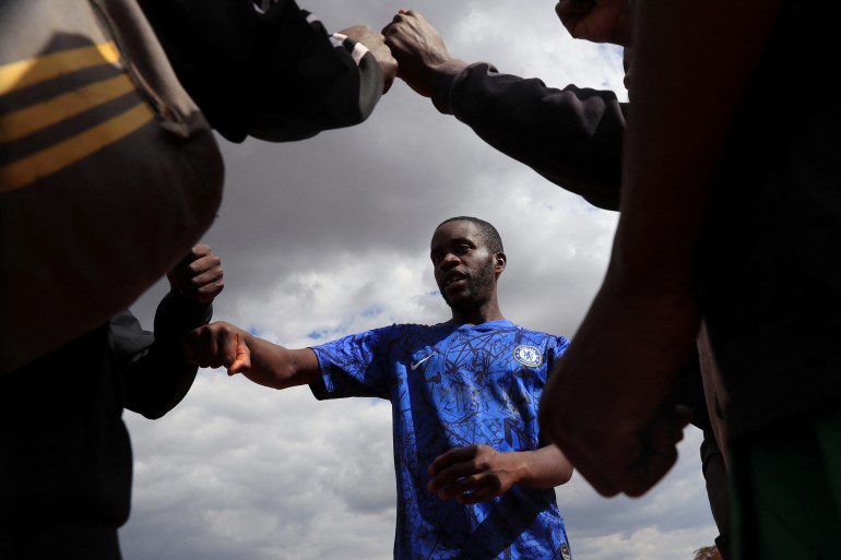 Tinotenda Mandizha, 25, a footballer and first-time voter greets his friends at Chimbumu playground in Kuwadzana, Harare, Zimbabwe