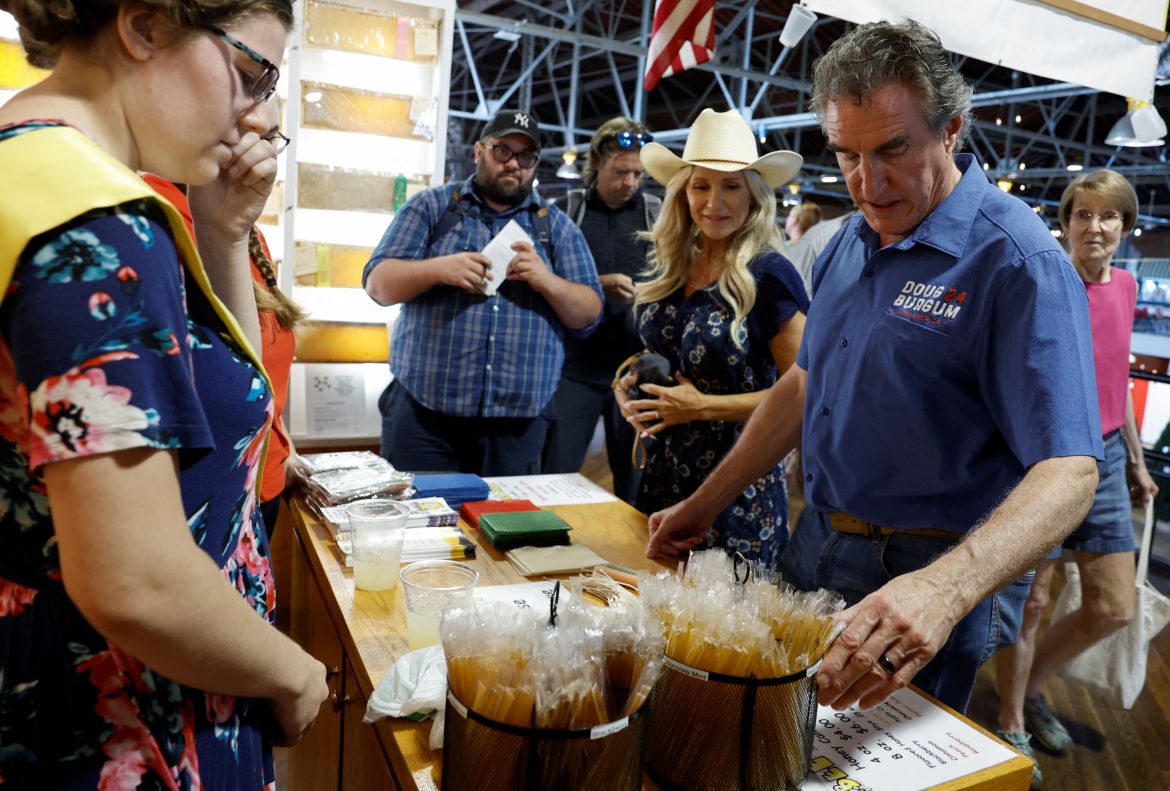 Republican U.S. presidential candidate and North Dakota Governor Doug Burgum and his wife, Kathryn Burgum, look at honey at the stand, at the Iowa State Fair in Des Moines, Iowa, U.S., August 11, 2023.