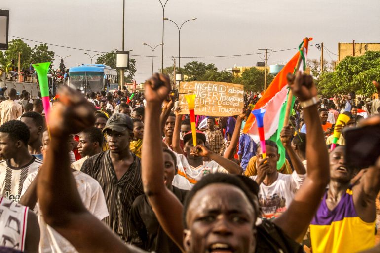 People take to the streets with raised fists and flags to show support for Niger's coup leaders.