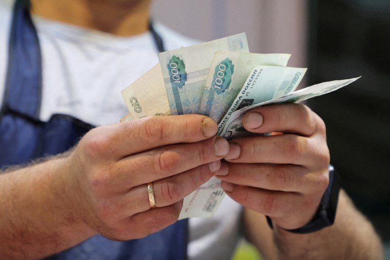 A vendor counts Russian rouble banknotes