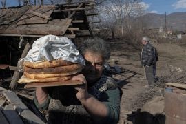FILE PHOTO: Local resident Zina Fatyan carries freshly baked bread in the village of Taghavard in the region of Nagorno-Karabakh, January 15, 2021. Picture taken January 15, 2021. REUTERS/Artem Mikryukov/File Photo