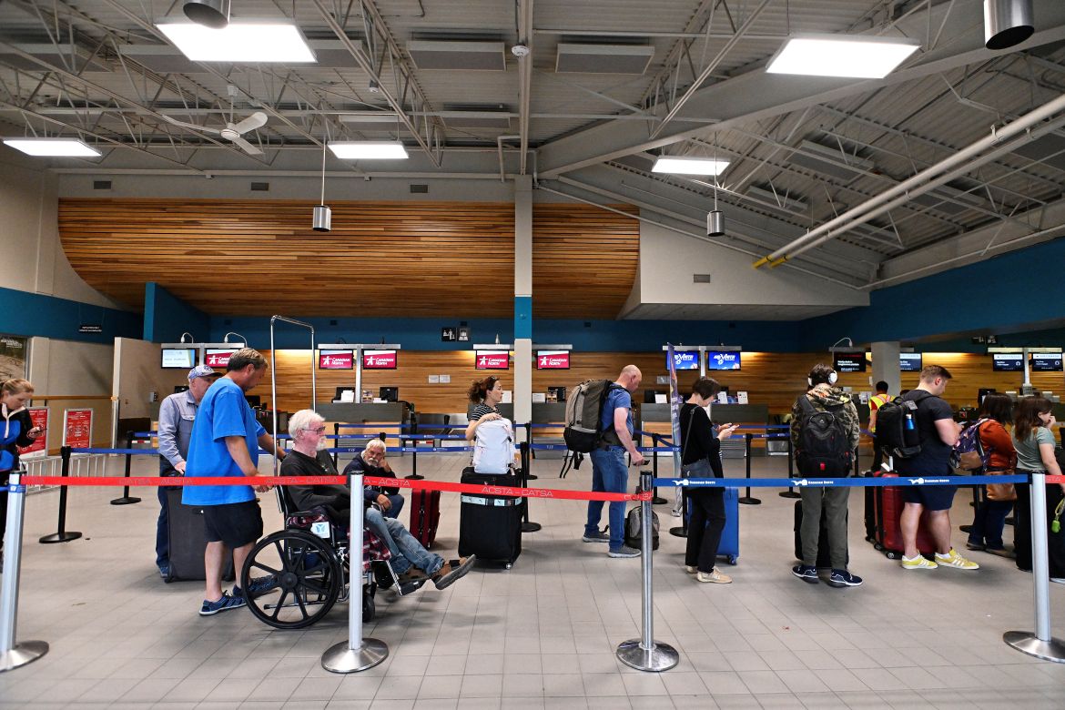People wait in line at the airport in Yellowknife, Northwest Territories, to evacuate from wildfires