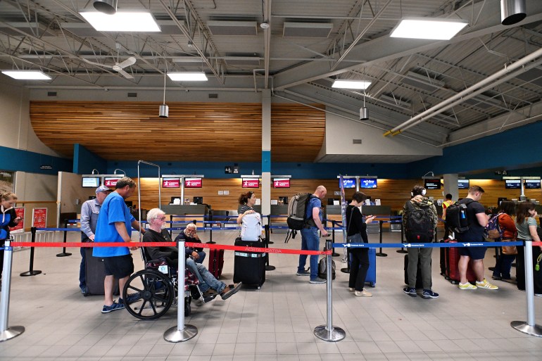 People wait in line at the airport as they prepare to leave the Northwest Territories