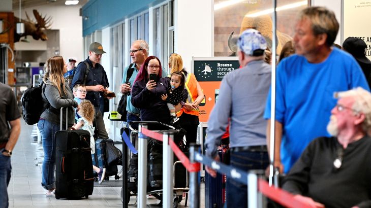 People wait in line at the airport in Yellowknife, Canada