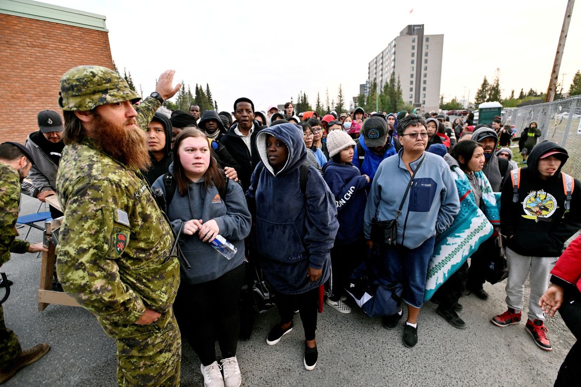People line up outside a school to register to be evacuated, in Yellowknife, Canada
