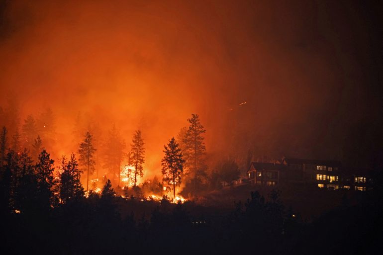 The McDougall Creek wildfire burns next to houses in the Okanagan community of West Kelowna, British Columbia, Canada, August 19, 2023.